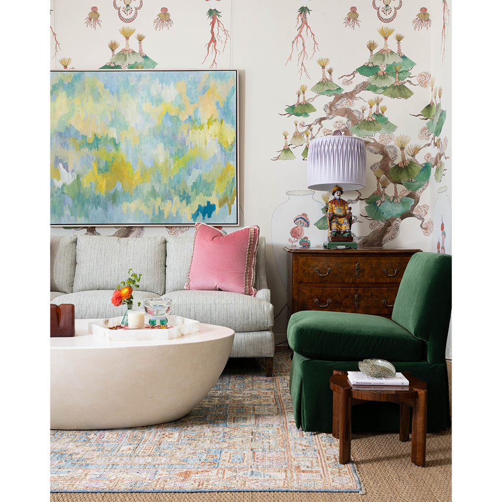 pink pillow, green chair and grey couch