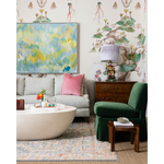 pink pillow, green chair and grey couch