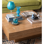 Rectangular wooden cocktail table with a high-gloss finish and striped grain pattern, decorated with blue glass vases and.