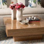 Rectangular wooden cocktail table with natural wood grain, featuring a stepped base and decorated with two white ceramic.