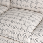 Cream sofa upholstery with a gray geometric grid pattern and tufted cushions.