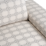 Cream fabric sofa upholstery with black geometric grid pattern and cushioned armrest detail.