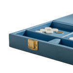 A close-up of a blue textured game box with a gold clasp, showing white and gold playing pieces inside on a white background.