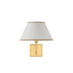 A modern wall-mounted table lamp with a square gold brass base, a vertical gold stem, and a tapered off-white fabric shade with a light wood trim at the top and bottom, shown against a plain white background.