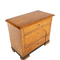 Annie Chest. A wooden chest with 3 total drawers. There is also a black stripe at the bottom of the chest just above the feet