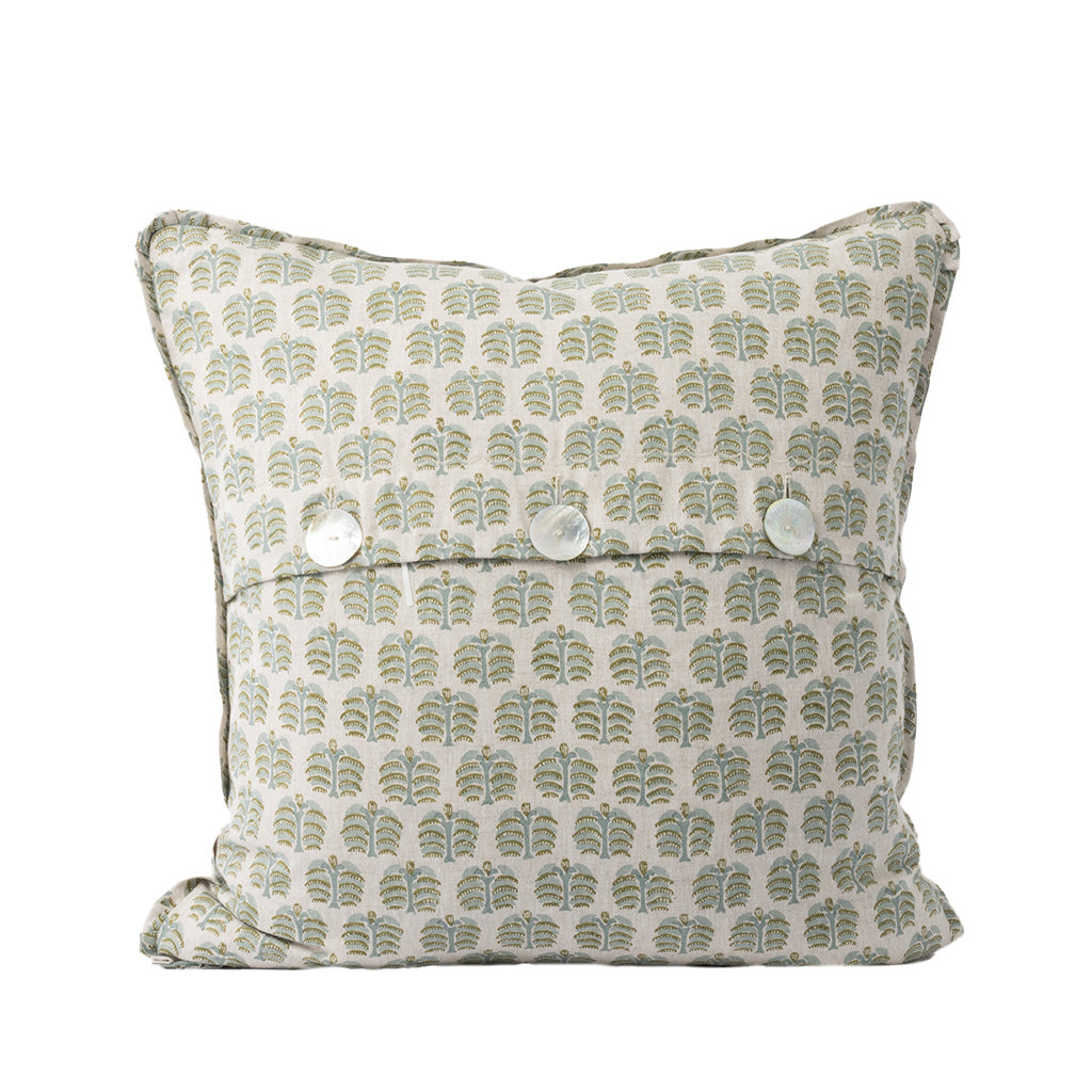 The back of the square decorative throw pillow features the same ivory fabric with a repeating sage green and golden tan botanical pattern as the front. An envelope-style closure secured with three white buttons provides a classic, functional finishing detail.