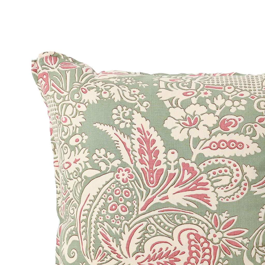 Decorative pillow with pink and white floral paisley pattern on a light green background
