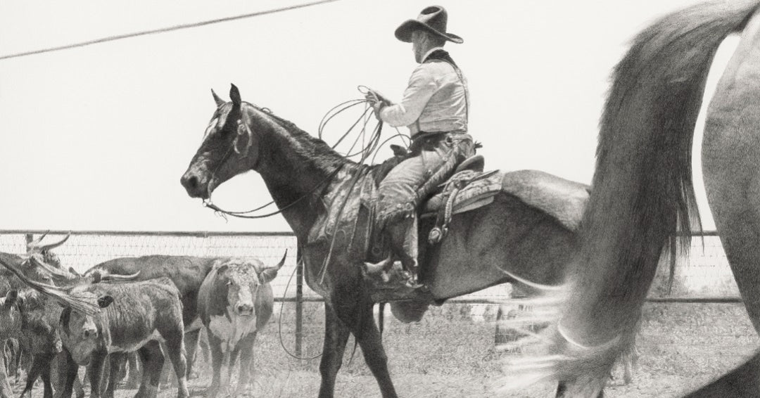 Cowboy on horseback with cattle in a pen