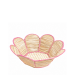 Scalloped woven raffia bowl at a tilted angle with pink trim and petal-shaped edges on a white background.