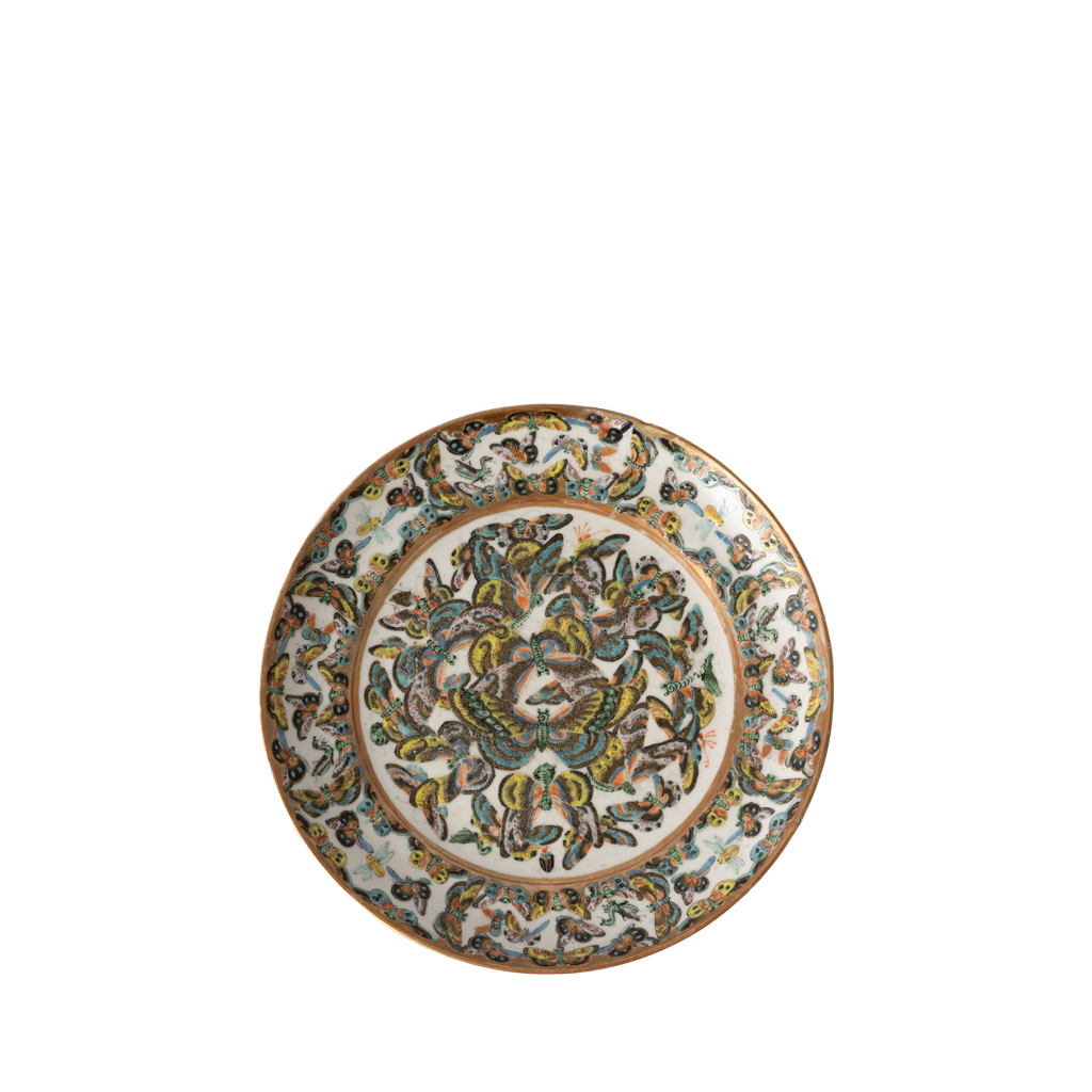 An ornate round ceramic plate featuring a detailed hand-painted butterfly motif in green, gold, and blue on a white background.