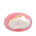 Pink dish with a white pearl inside on a white background