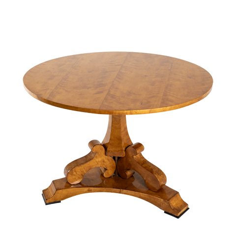 Clara Wooden Table with a flat circular top and intricate legs