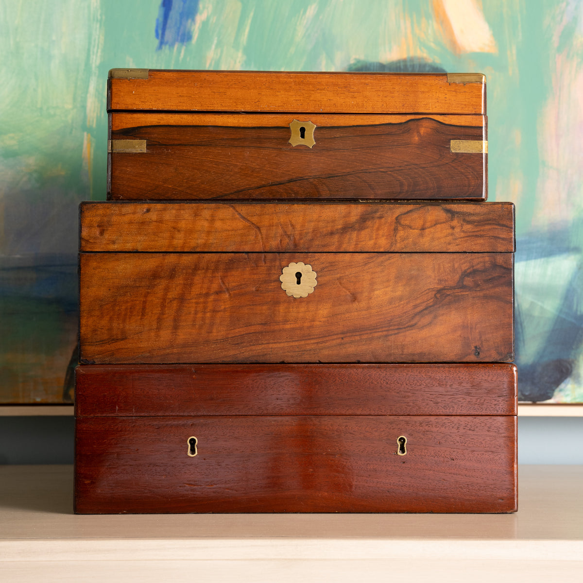Stack of wooden boxes with brass locks against a colorful abstract background