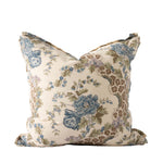 Decorative square pillow featuring an elegant botanical print with large blue flowers, delicate floral sprigs, and olive green foliage against a warm ivory background. Soft lavender accents and winding brown branches add depth to the traditional floral design.