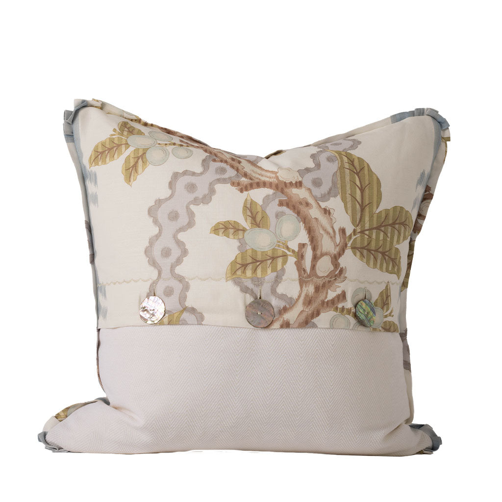 Back of the decorative pillow featuring a combination of the botanical print and a coordinating ivory herringbone fabric. Three decorative shell-style buttons accent the center closure, adding a handcrafted finishing detail.