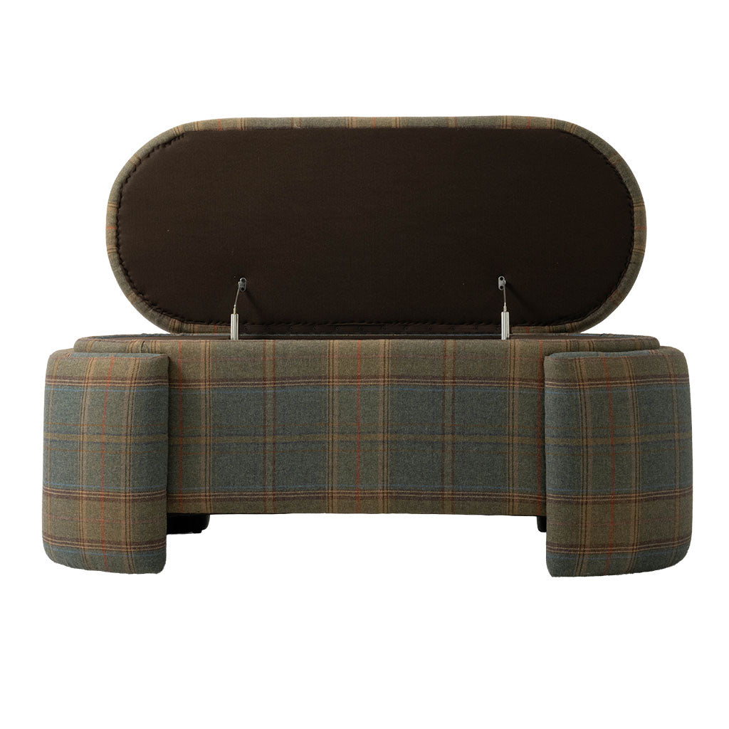Front view of the upholstered plaid bench with its hinged seat lifted to reveal a hidden storage compartment. The bench features muted green, brown, and rust plaid upholstery with substantial rounded legs at each end.