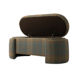 Three-quarter view of the plaid upholstered bench with its hinged seat raised to reveal the hidden storage compartment. The image highlights the lift-top construction, dark-lined underside, and muted green, brown, and rust plaid upholstery.