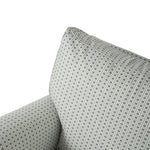 Close-up of the chair’s back and arm, highlighting the tailored upholstery and softly cushioned construction. The miniature geometric pattern continues seamlessly across the chair.