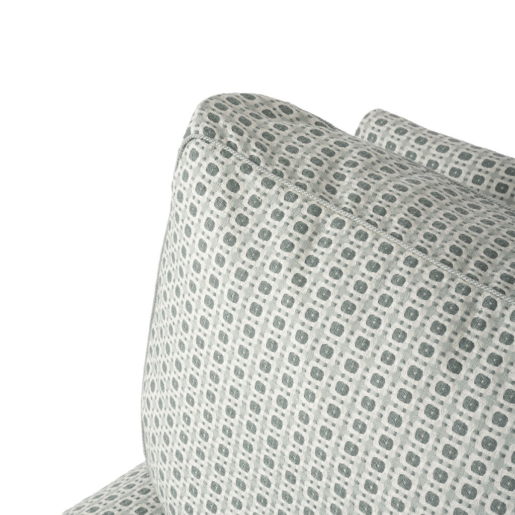 Close-up of the chair upholstery showing the small-scale repeating geometric motif. The soft gray and cream palette gives the patterned fabric a subtle, textured appearance.