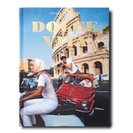 A book cover of 'Dolce Vita' featuring a color photograph with a woman in a white dress sitting on a car hood, with the Colosseum and a red vintage car in the background.