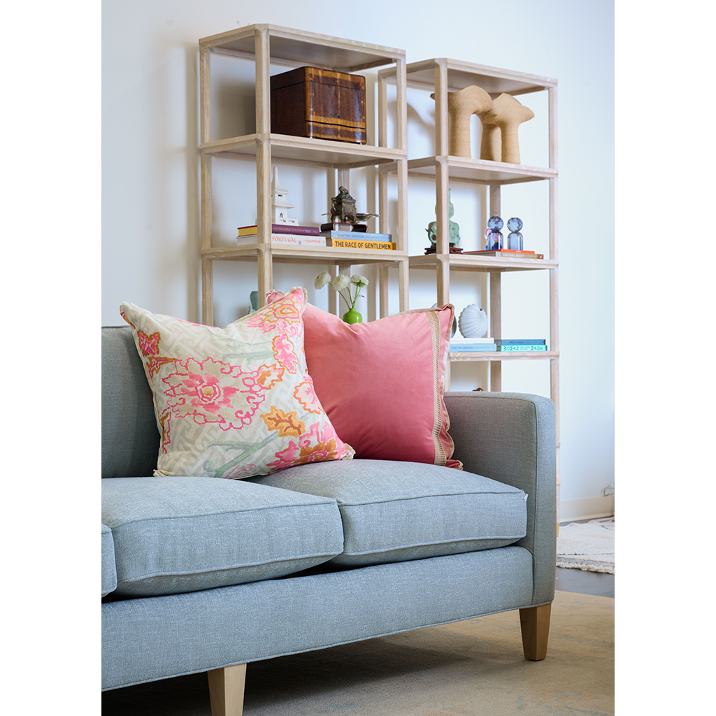 blue denim couch with floral pillow and pink velvet pillow