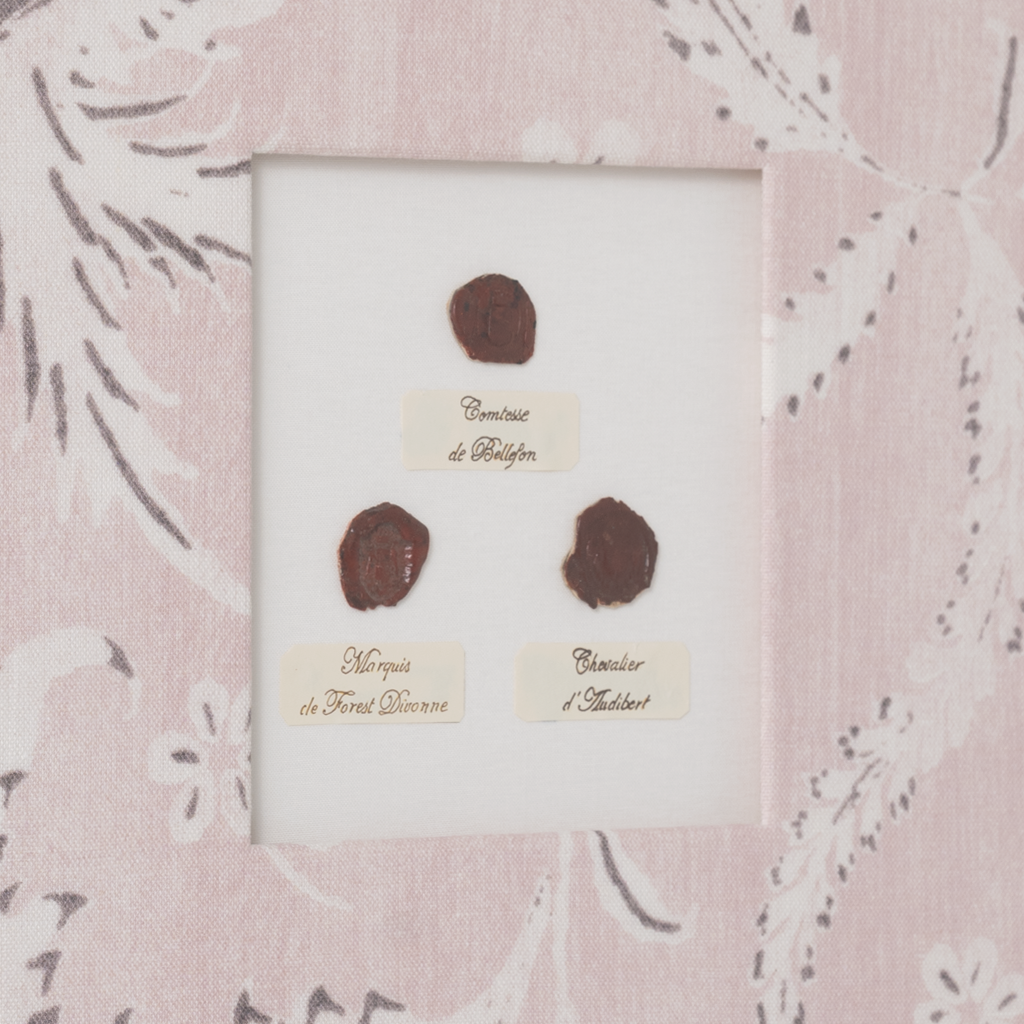 Three antique stamps with labels in a decorative frame on a floral-patterned background