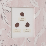 Three antique stamps with labels in a decorative frame on a floral-patterned background