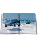 Open book showing a photograph of two cars on a snowy landscape with text underneath.