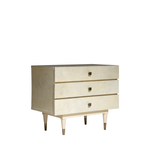 Beige dresser with three drawers on a white background