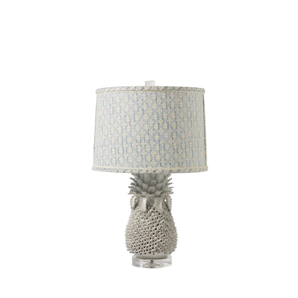 Table lamp with pineapple base and patterned shade on a white background