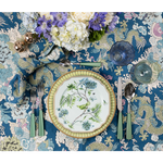 Blue and cream patterned Magic Mountain Napkin with intricate floral and dragon designs under a white plate with bird.