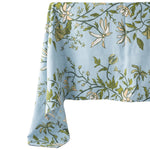 blue and green botanical tablecloth draped off a table on a white background