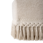 Close-up of a textured fabric with macrame tassels on a white background