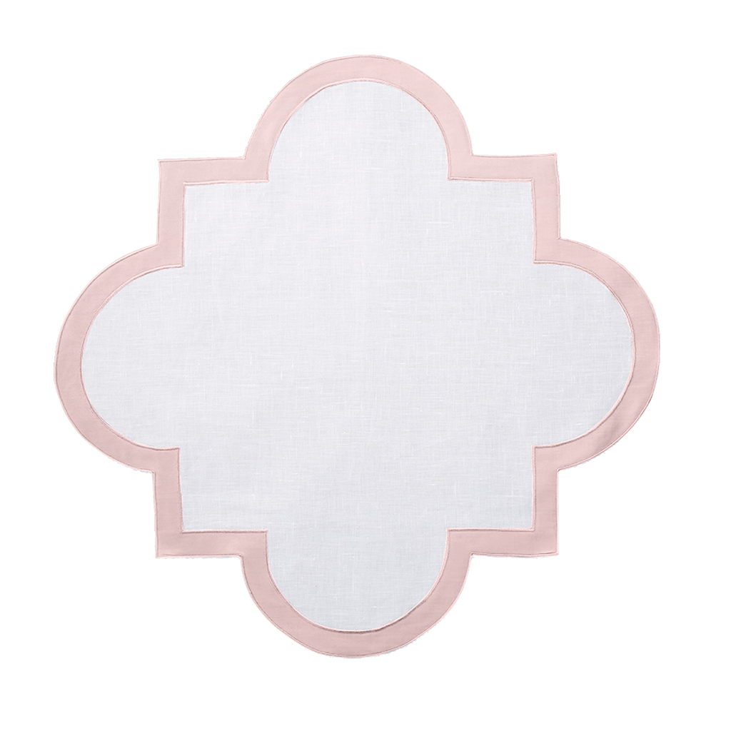 White linen placemat with scalloped quatrefoil shape and soft pink border trim.