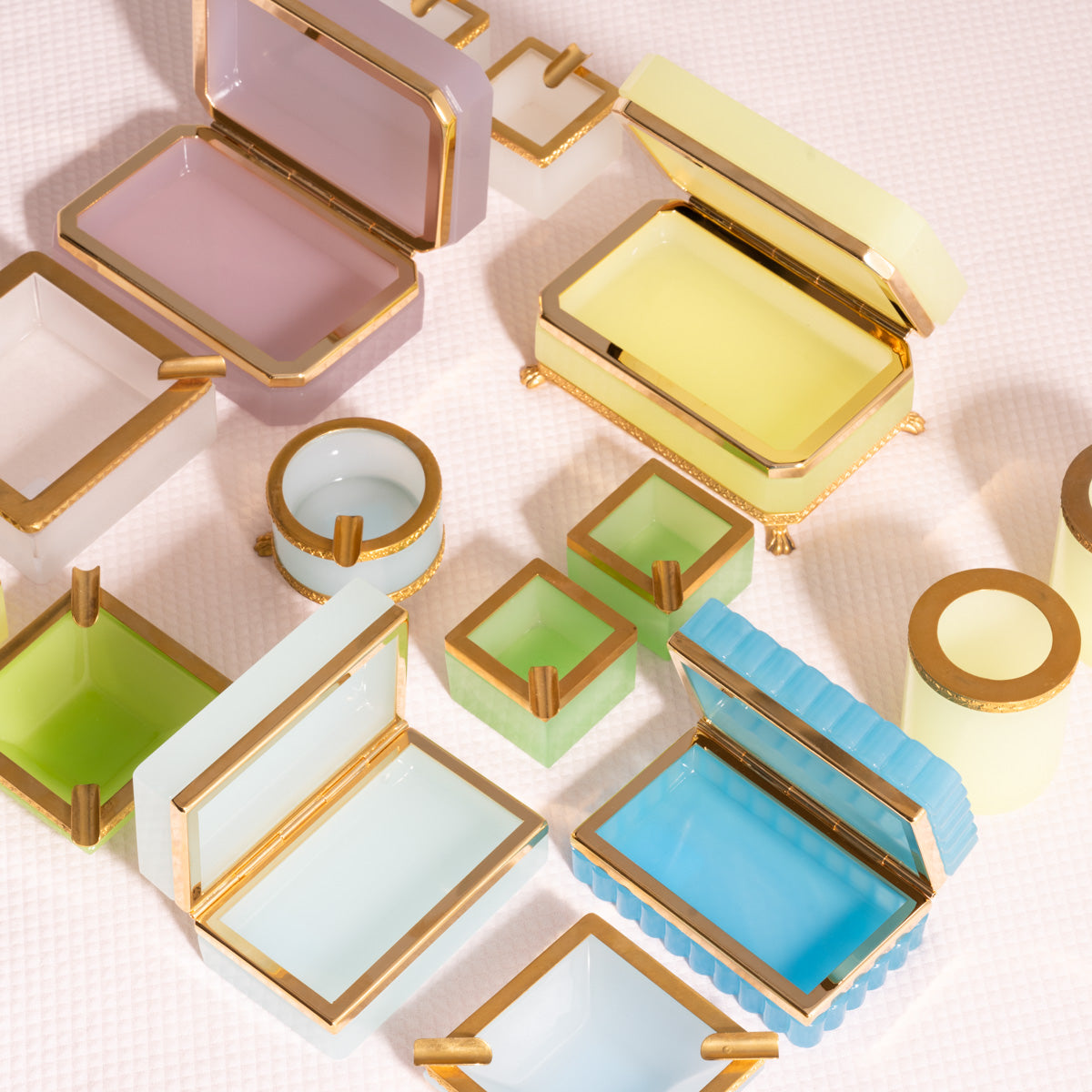 Colorful jewelry boxes with gold accents on a light background