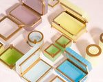 Colorful jewelry boxes with gold accents on a light background