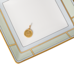 Gold pendant on a decorative white and gold frame