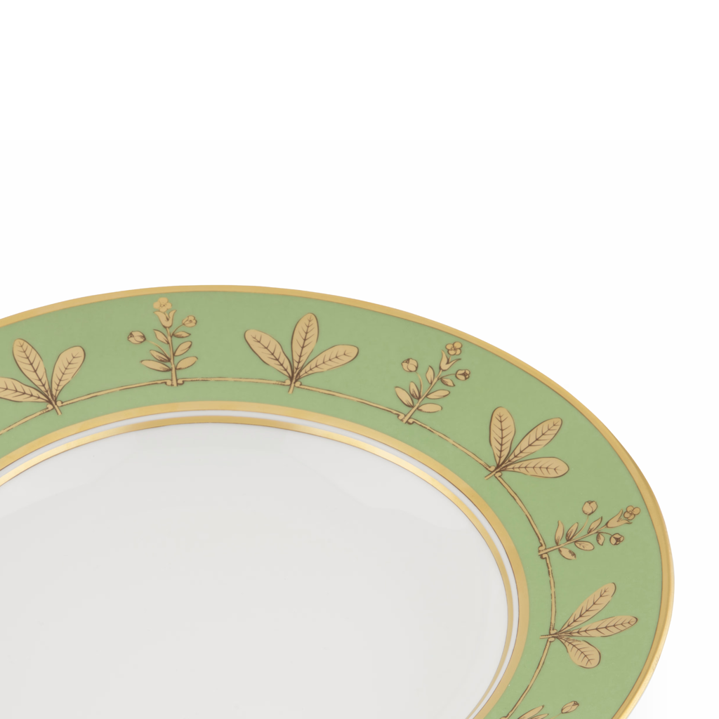 Green plate with gold leaf patterns on a white background