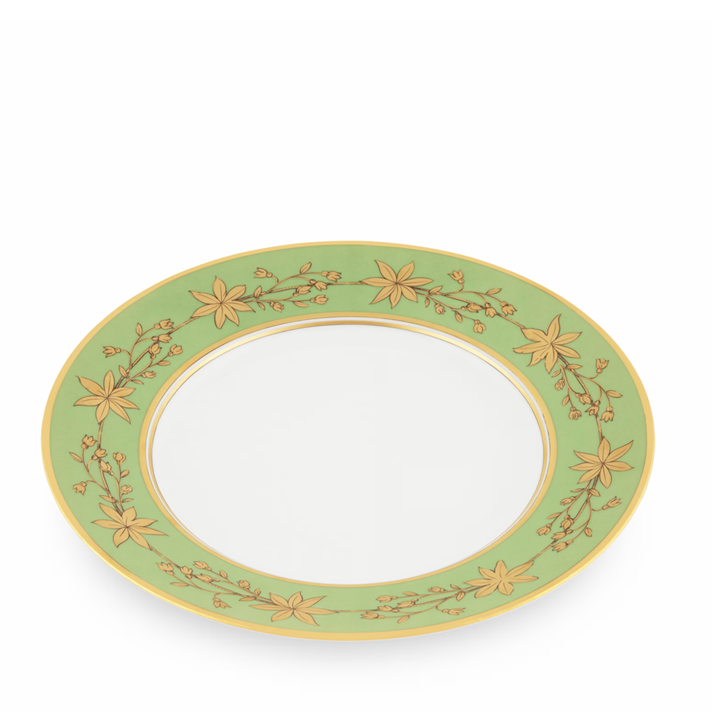 Angled green decorative dinner plate with gold leaf pattern on a white background