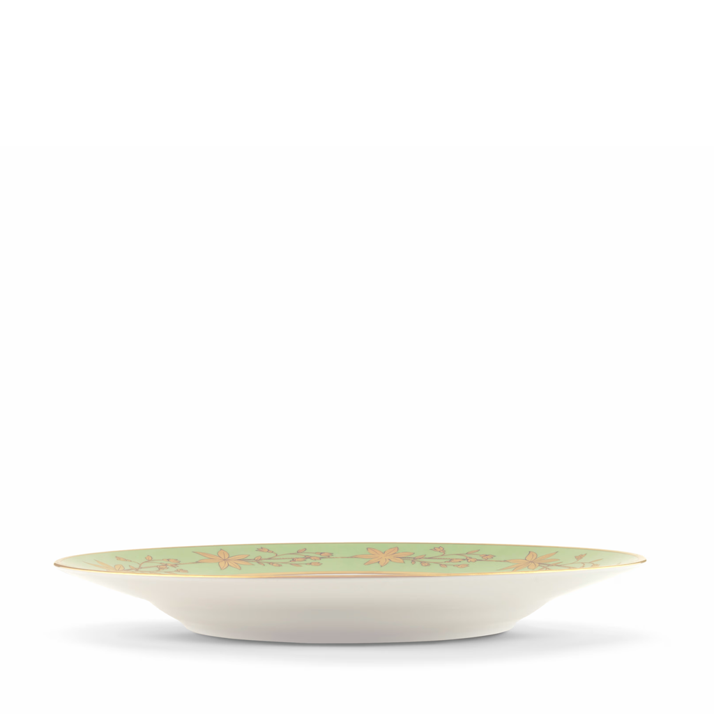 Side angle of a green decorative dinner plate with gold leaf pattern on a white background