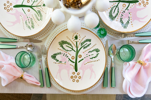 A tablescape with plates with pink reindeers
