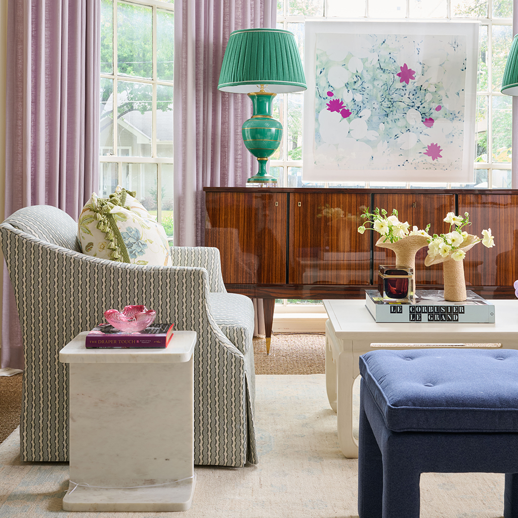 White marble Solstice Side Table with rectangular top next to gray upholstered armchair in living room setting.