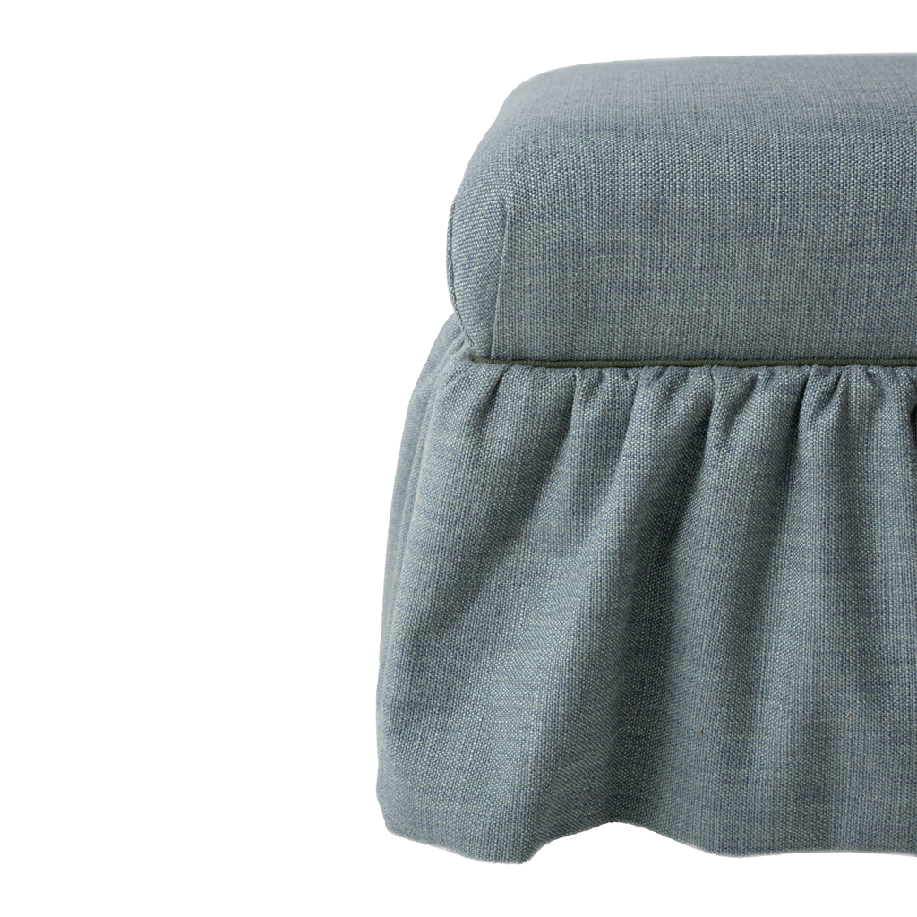 Blue upholstered ottoman with ruffle skirt