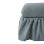 Blue upholstered ottoman with ruffle skirt