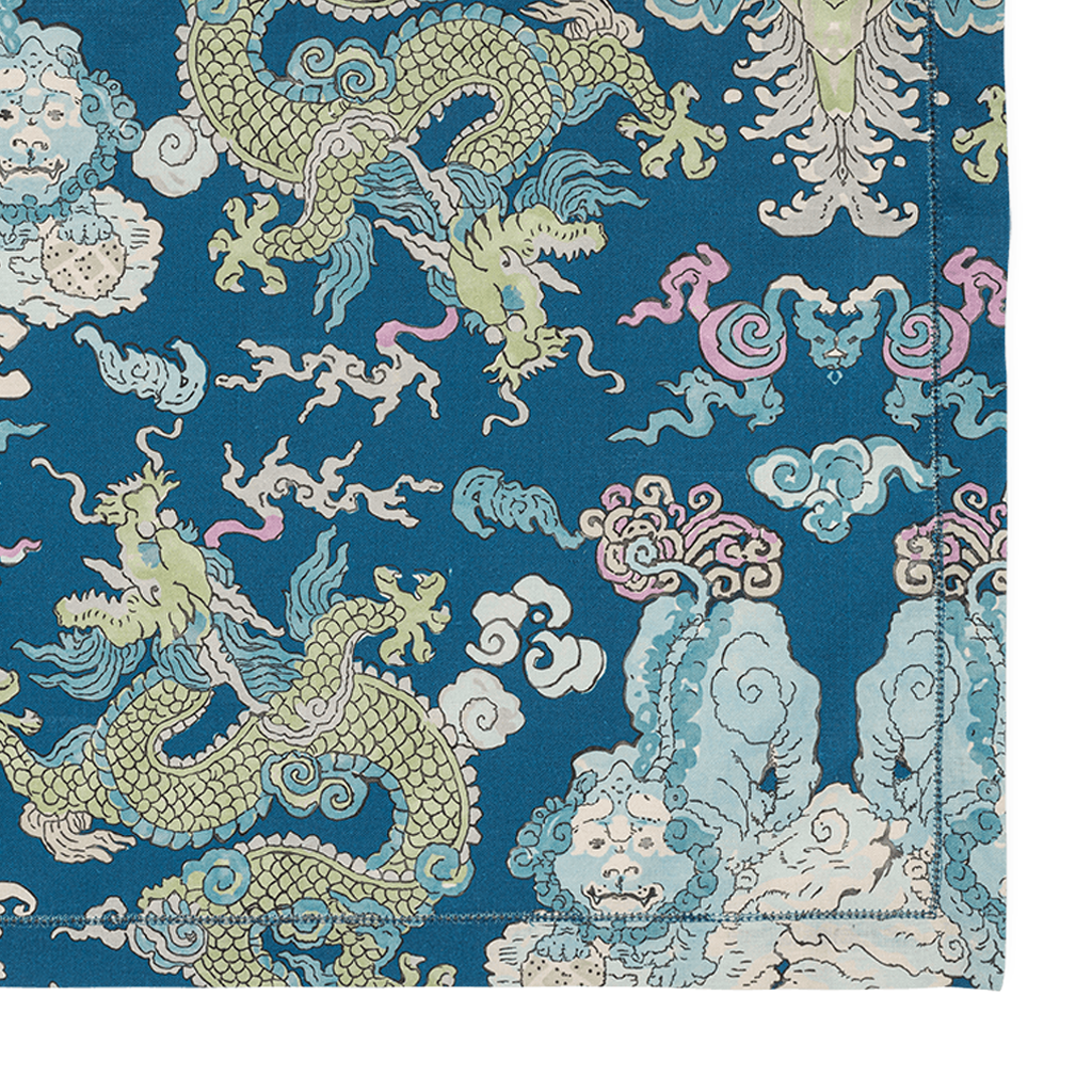 Blue tablecloth with intricate oriental dragons, clouds, and mountain motifs in green, pink, and beige.