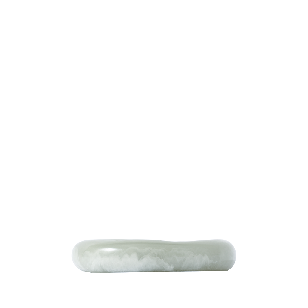 Side angle of a green resin catch-all dish on a white background