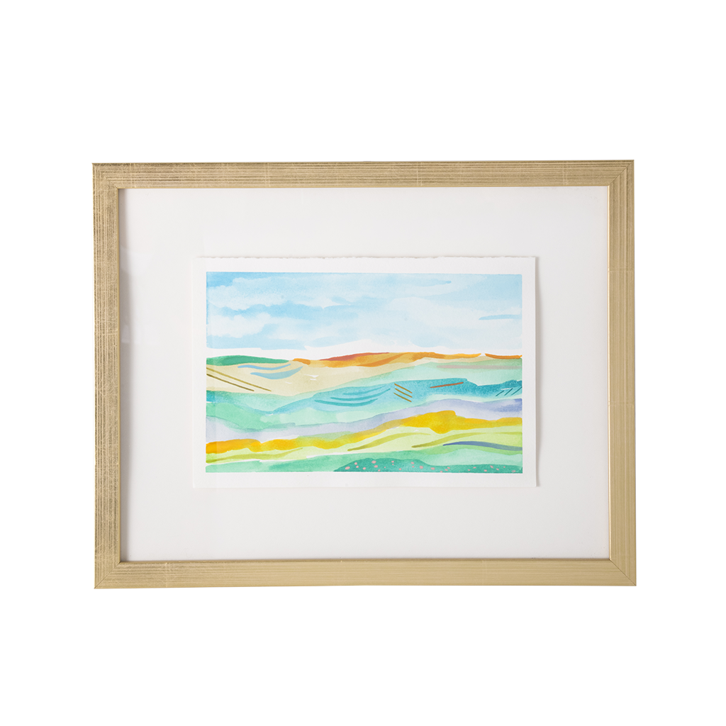 Framed abstract landscape art print with layered wavy lines in blue, green, yellow, and orange, set in a light wood frame with a white mat on a white background.
