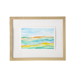 Framed abstract landscape art print with layered wavy lines in blue, green, yellow, and orange, set in a light wood frame with a white mat on a white background.
