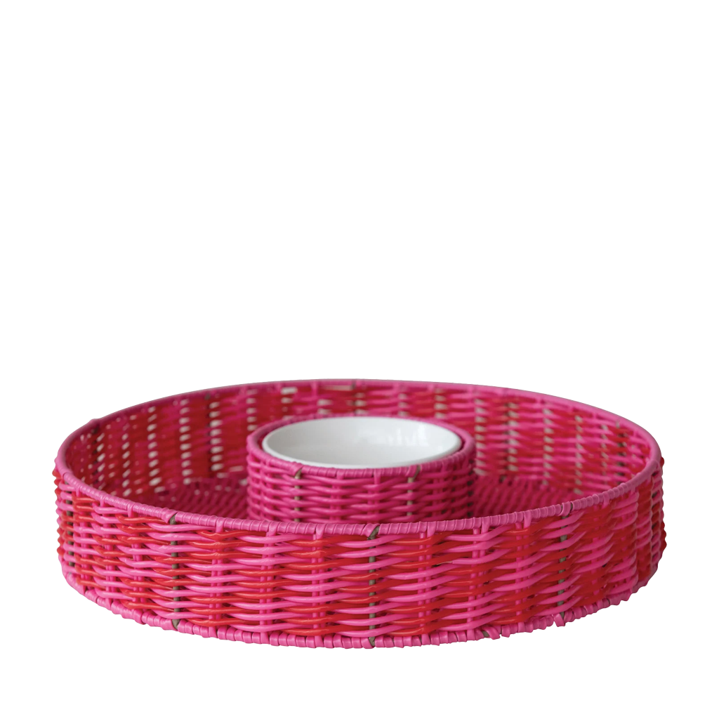 Pink woven chip and dip basket with a white interior on a white background