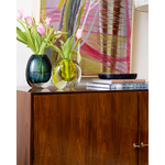 Decorative scene with colorful vases and tulips on a wooden cabinet.
